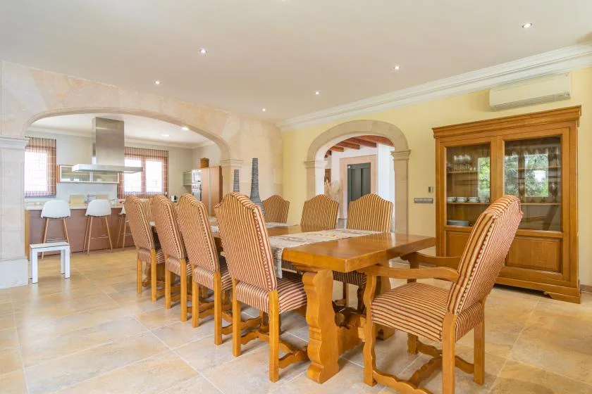 A dining room with a large wooden table and upholstered seating.