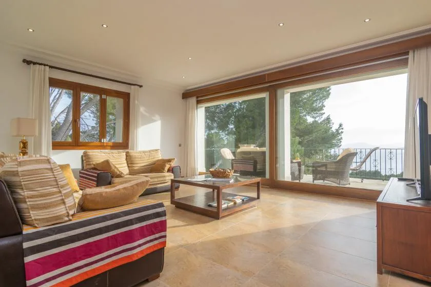 A bright living room opens onto a patio through large glass doors.