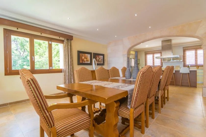 A dining room with a long wooden table and upholstered seating.