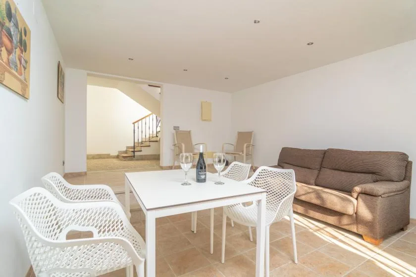 A living room with a brown sofa and white table surrounded by seating.