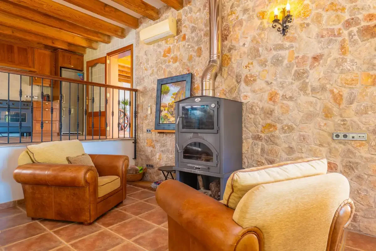 A rustic living room with two armchairs and a freestanding stove.