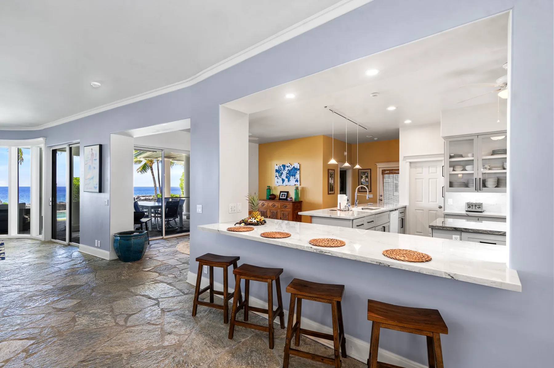 Una cocina amplia con una barra larga y taburetes se abre a un comedor.