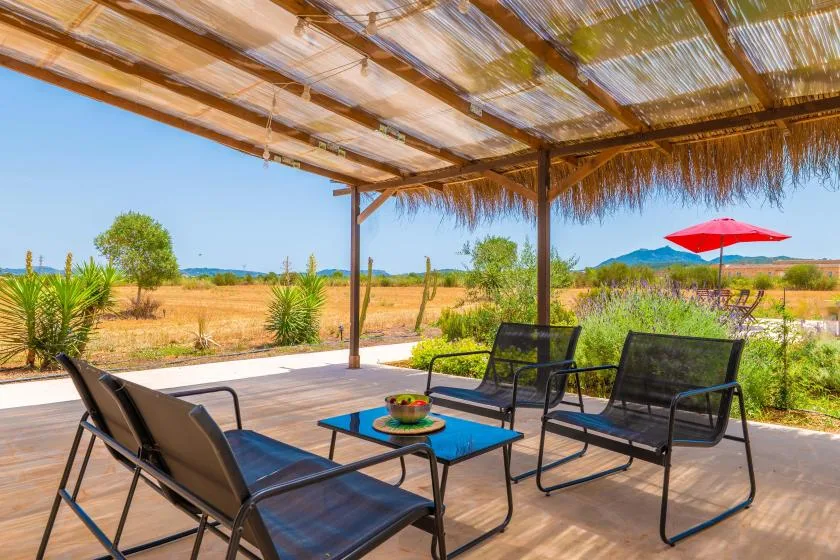 A shaded outdoor seating area overlooks a dry, open landscape.