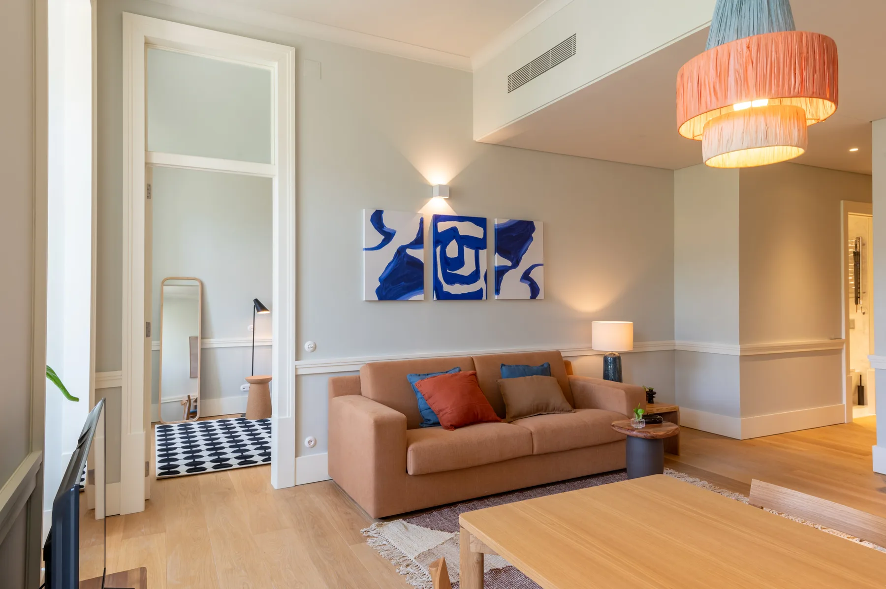 Living room with seating, a coffee table, and blue artwork on the wall.