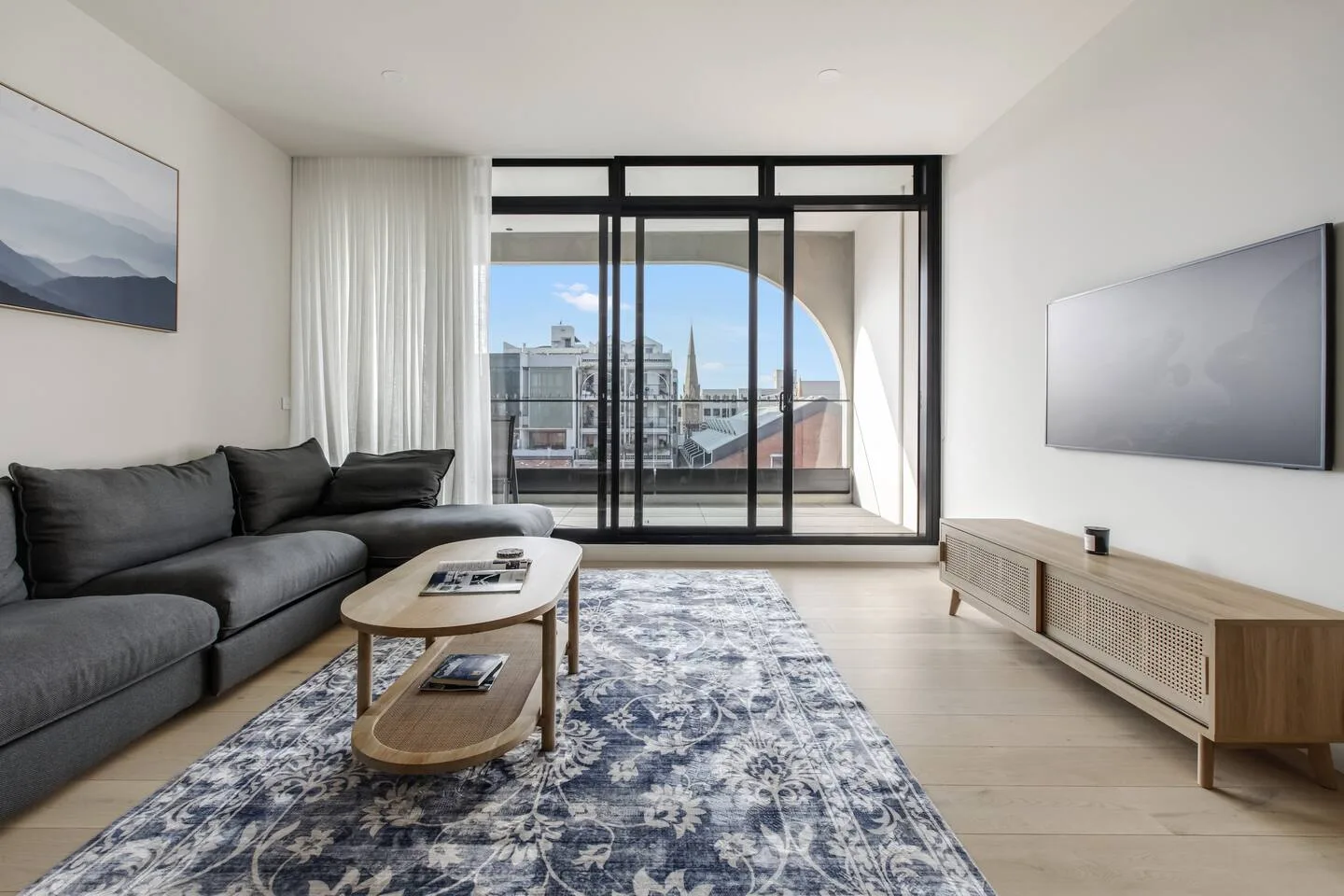 Una sala de estar con asientos alrededor de una mesa de centro y una ventana grande.