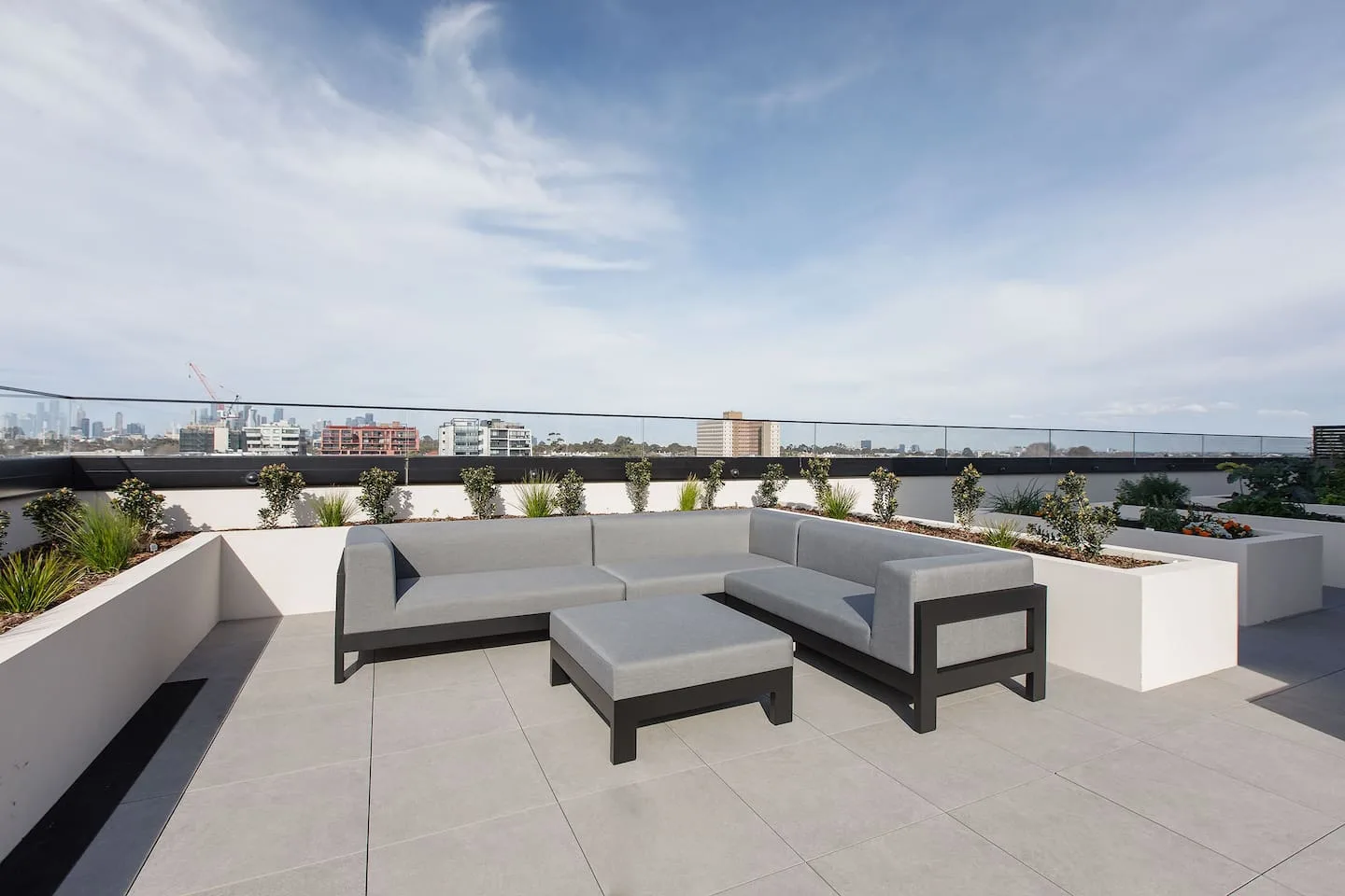 Una terraza en la azotea tiene asientos al aire libre y vistas a la ciudad.