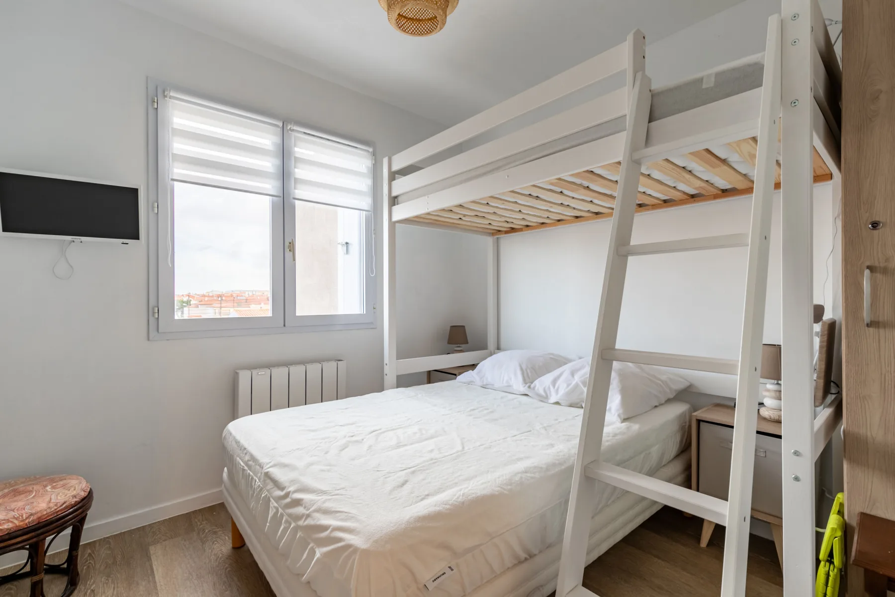 Bedroom with a bed beneath a white bunk bed.