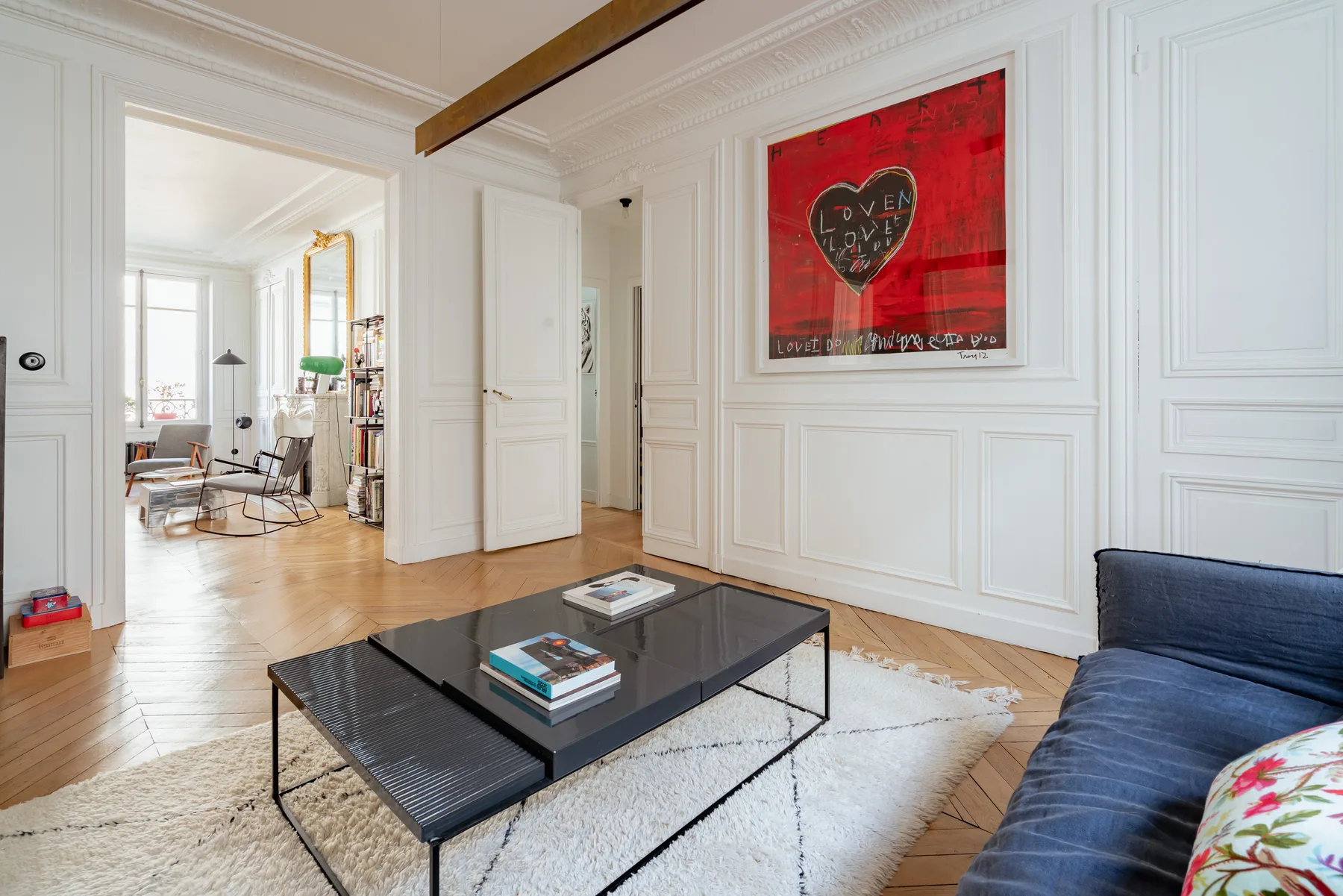 A bright living room with a low coffee table and blue seating.