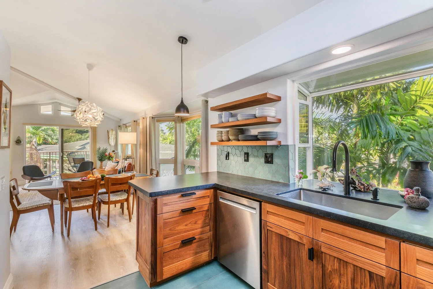 An open-plan kitchen and dining area with wooden cabinets and a large window.