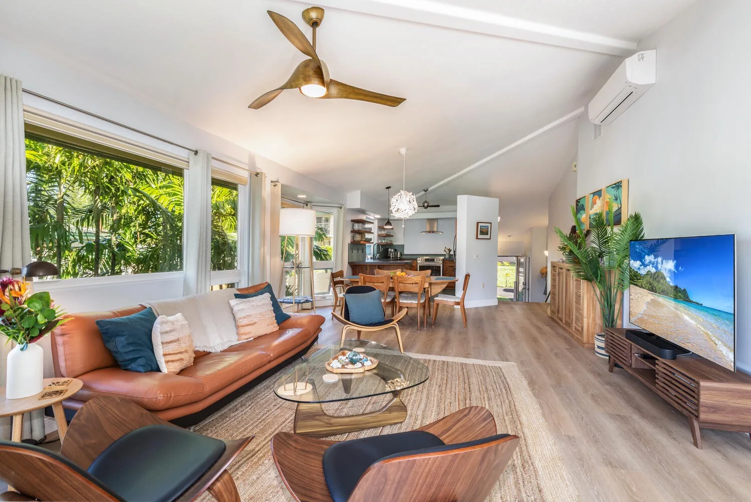 An open-plan living room with seating, a television, and a dining area.