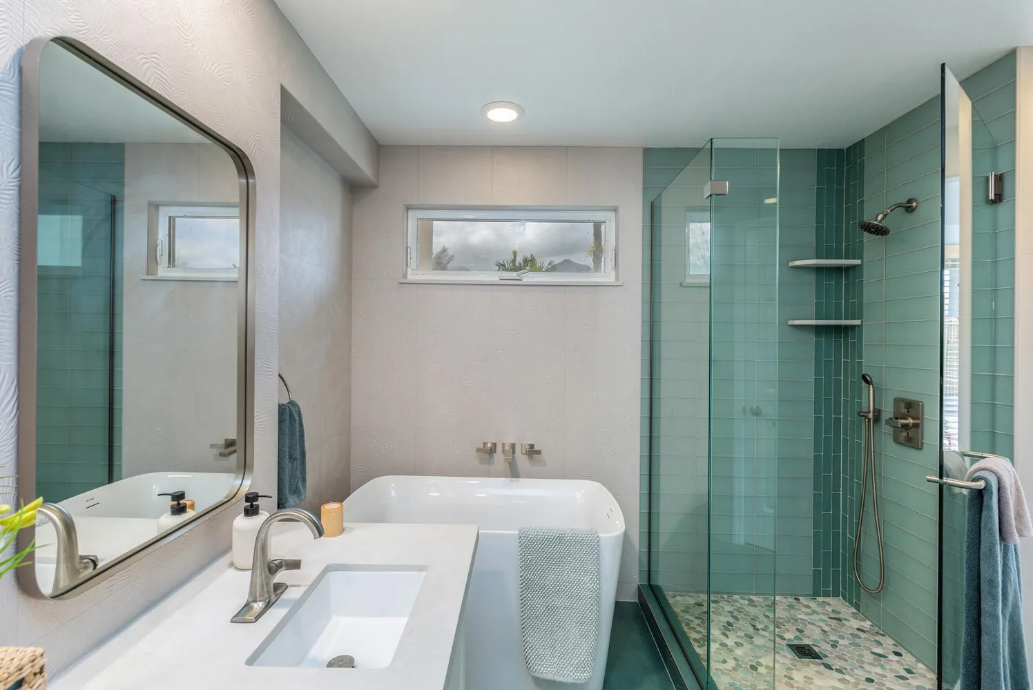 A bathroom with a sink, bathtub, and glass shower area.