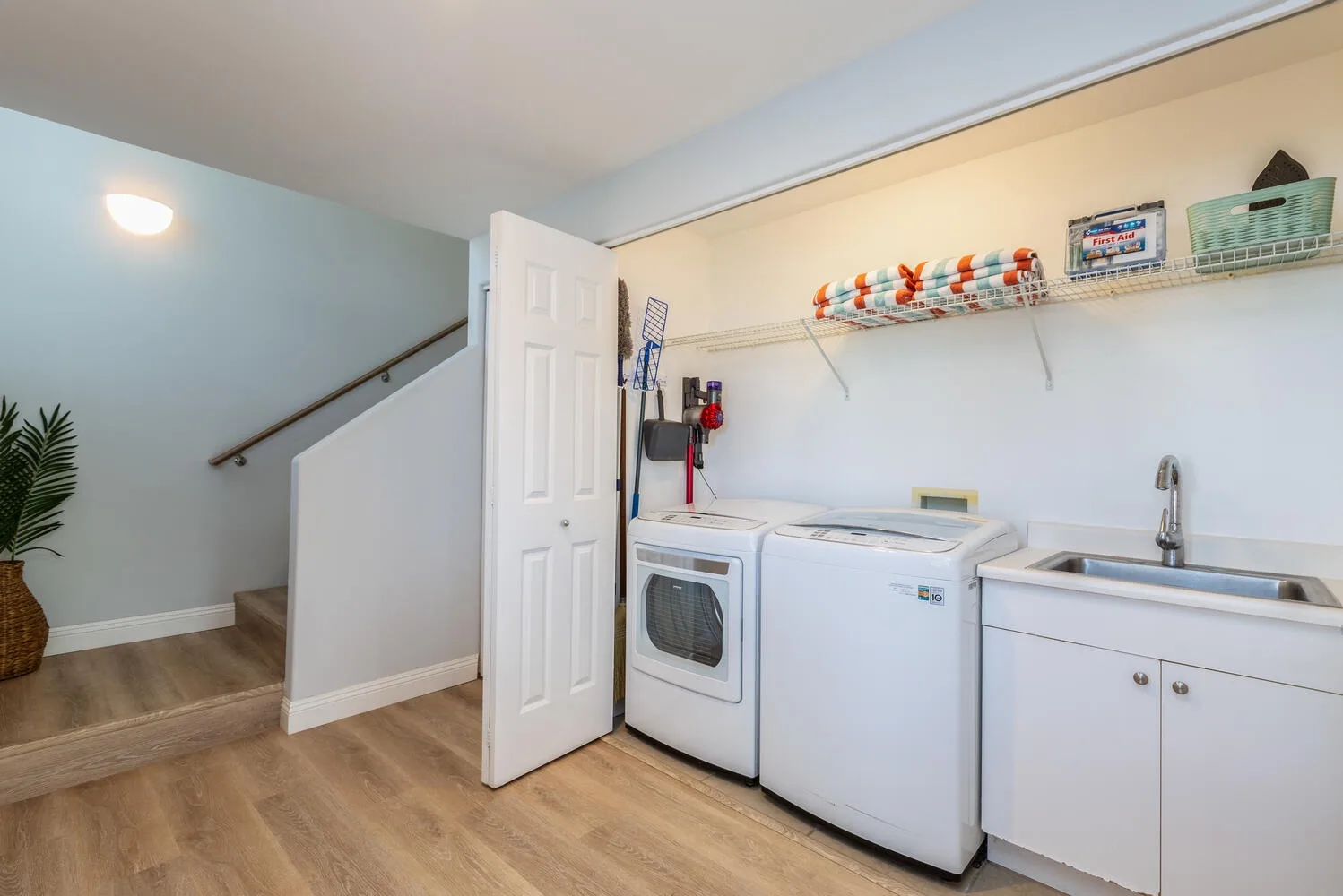 A laundry room with a washer, dryer, and utility sink.
