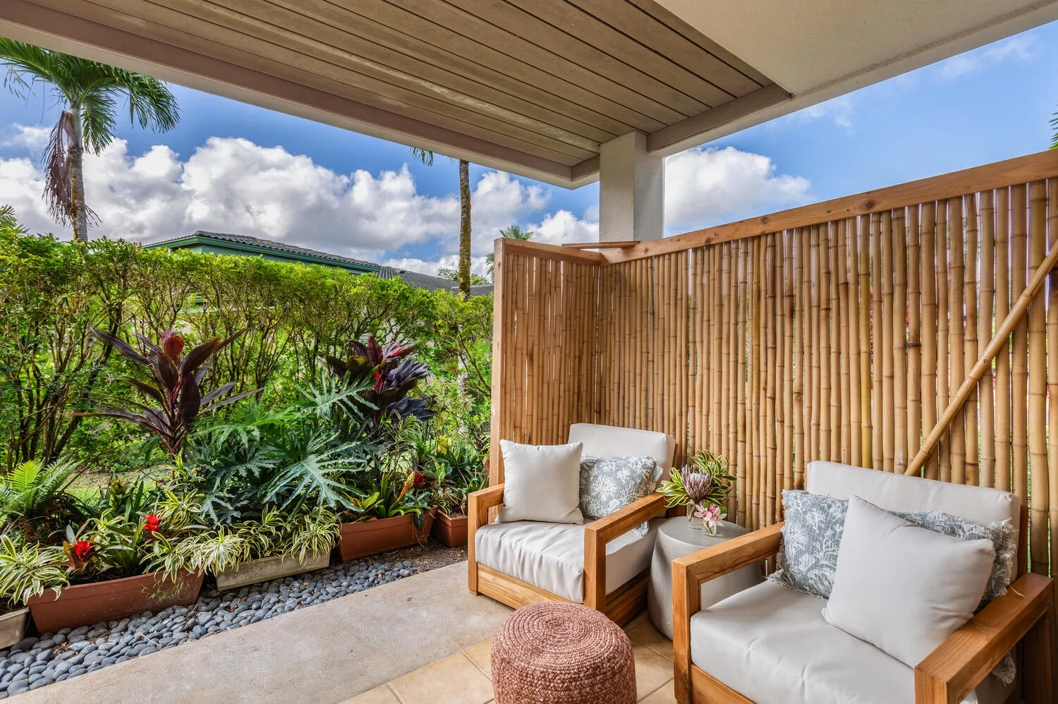 A covered outdoor seating area overlooks lush tropical plants.