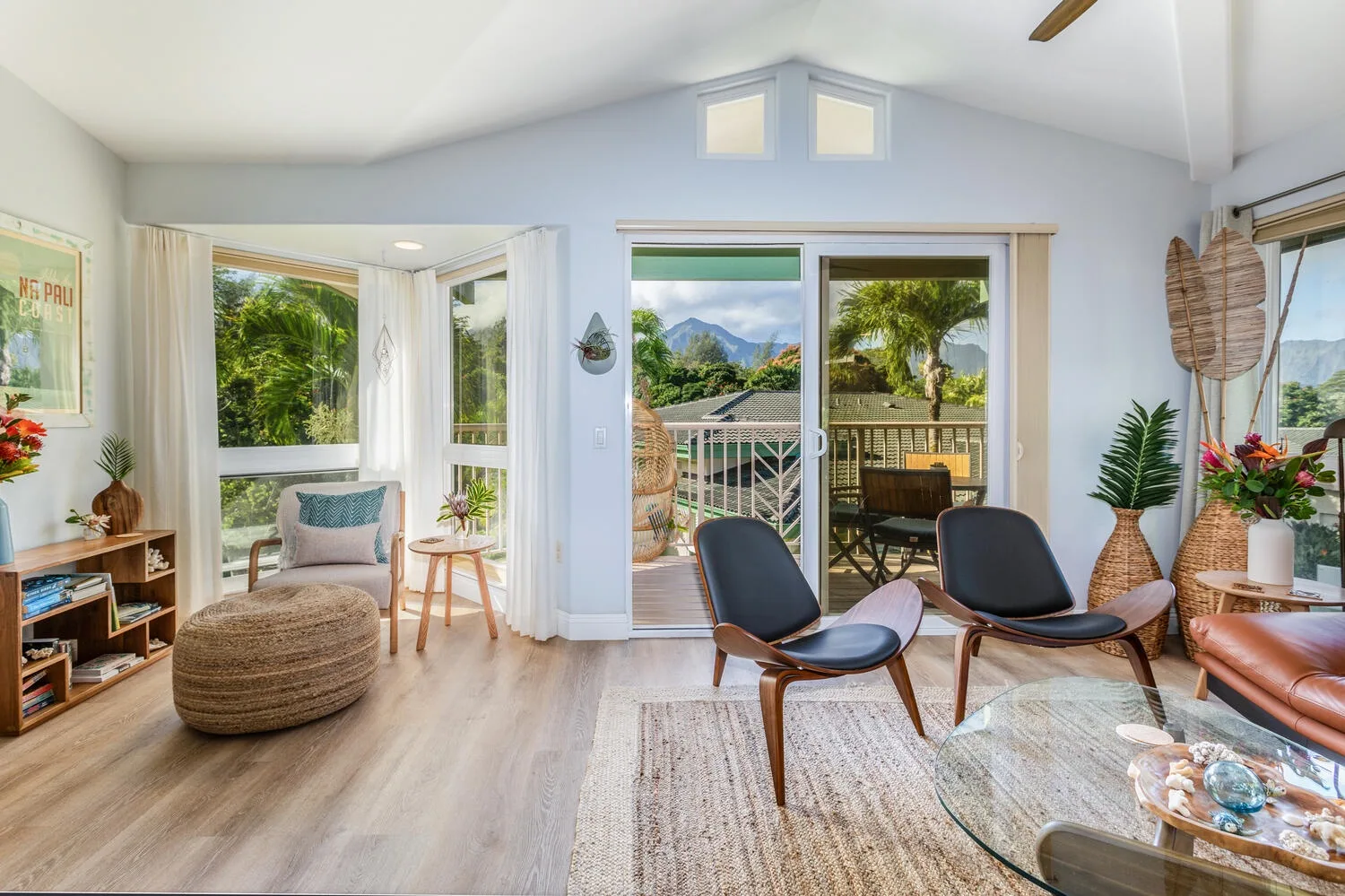 A bright living room with seating beside large windows and glass doors.