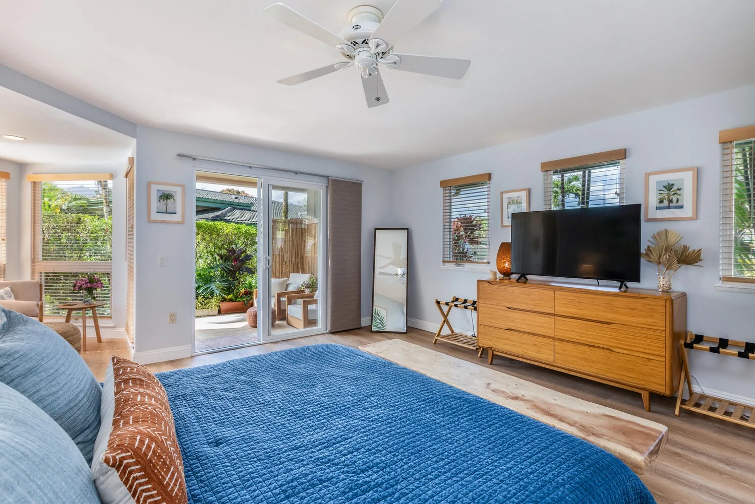 Living room with a blue rug, television, and sliding glass doors opening to a patio.