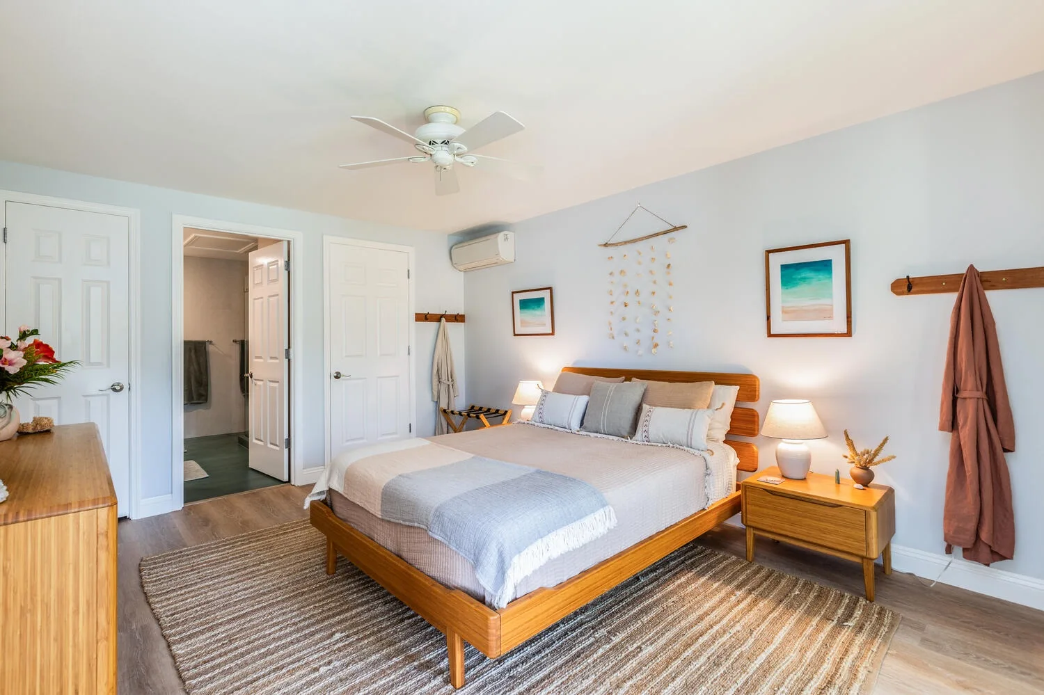 A bedroom with a wooden bed, bedside tables, and a ceiling fan.