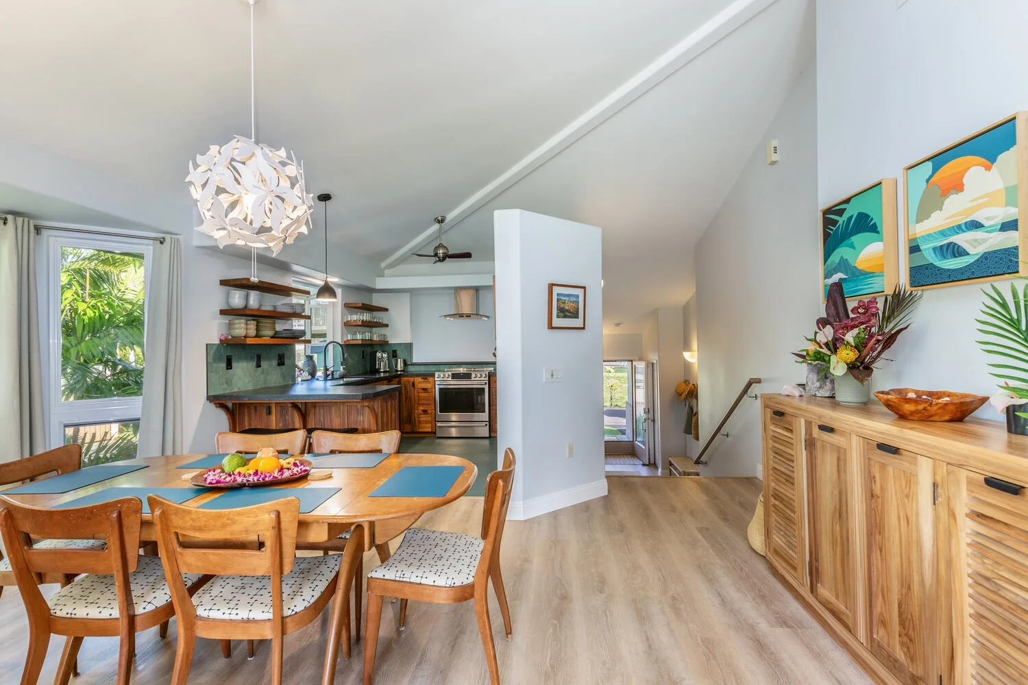 An open-plan dining area and kitchen with a wooden table and counter.