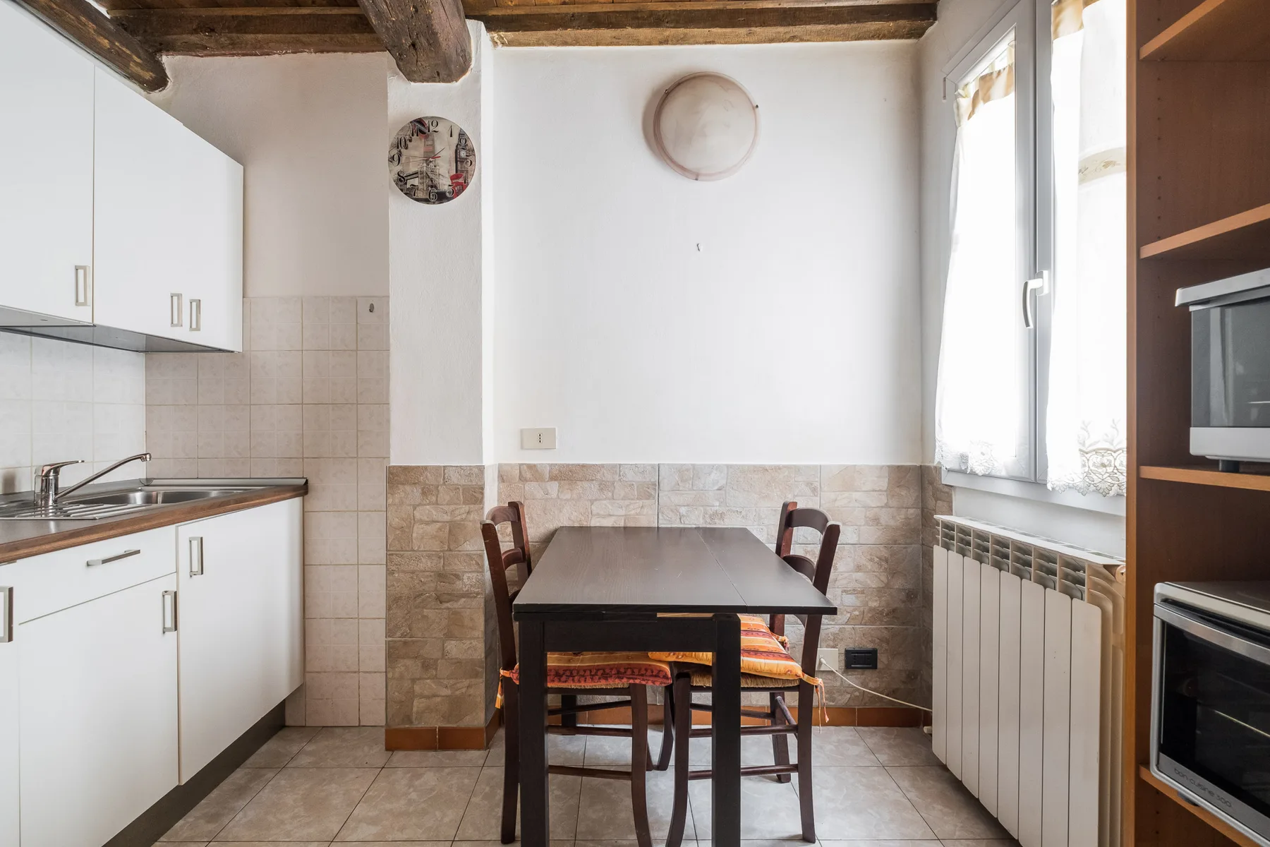 A small kitchen dining area with a table beside a bright window.