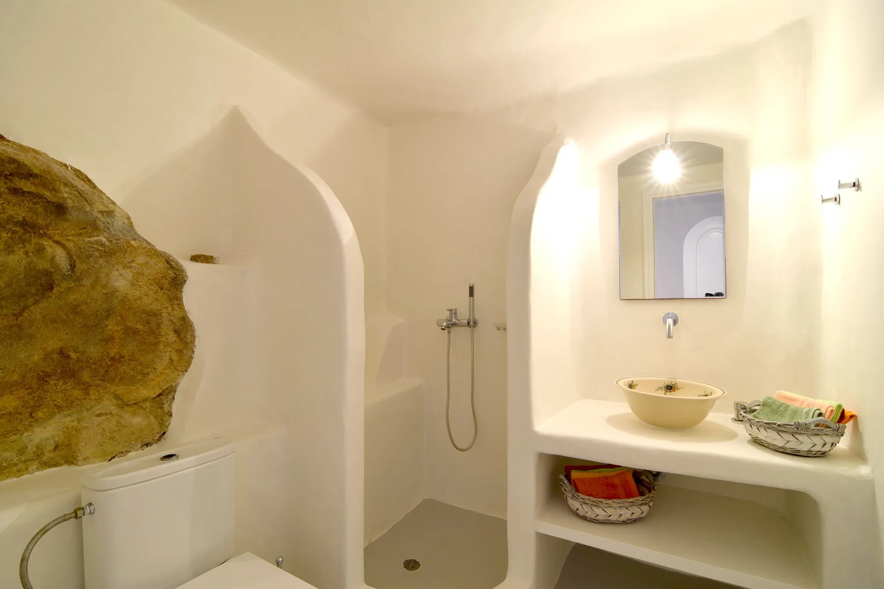 A bathroom with a shower and a sink beneath a mirror.