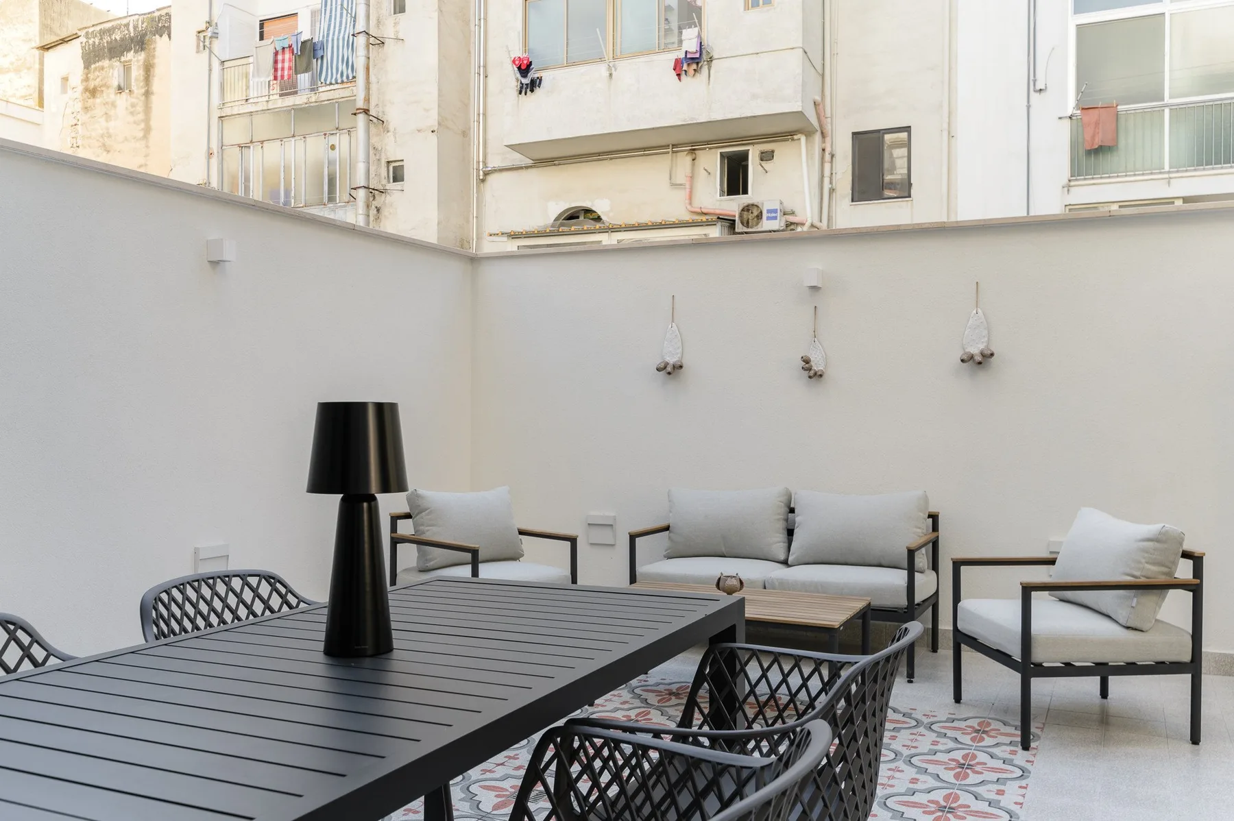 A furnished outdoor patio with a dining table and cushioned seating.