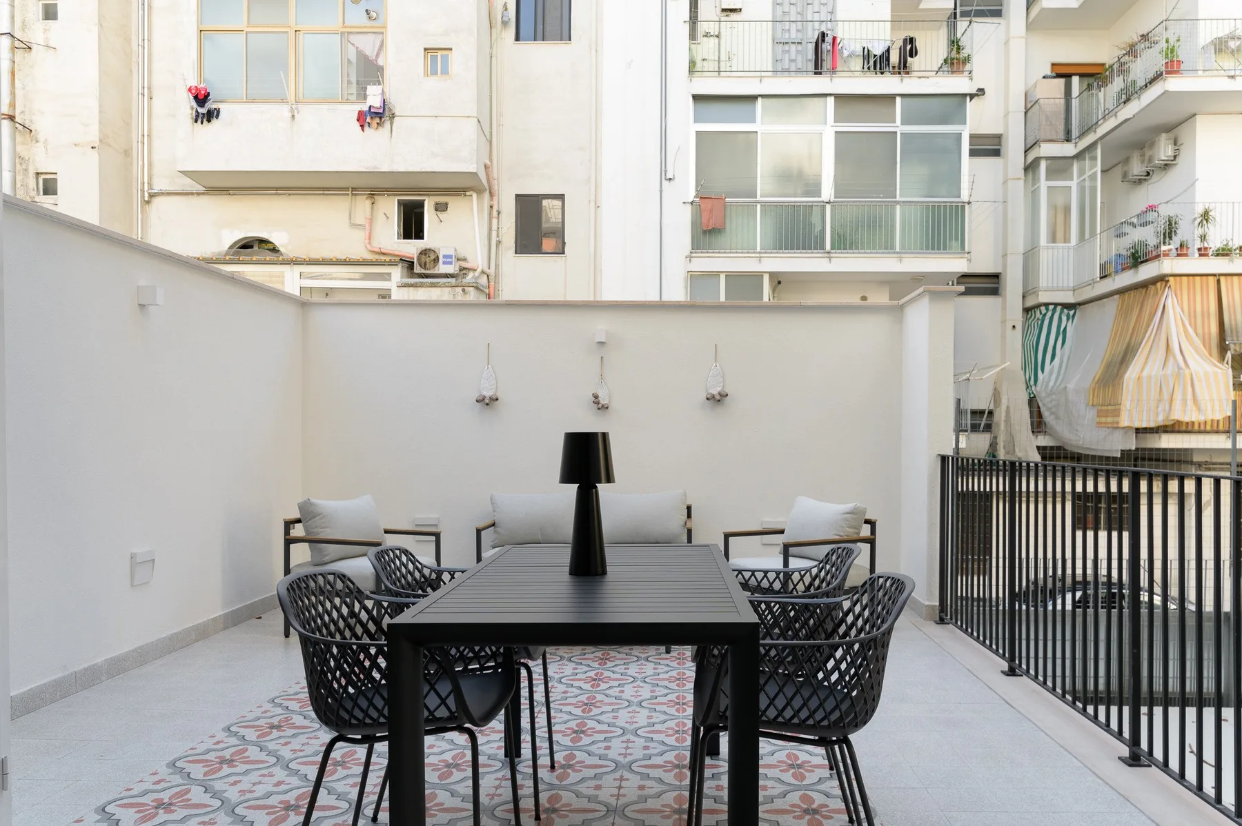 A furnished outdoor dining area with a dark table and chairs.