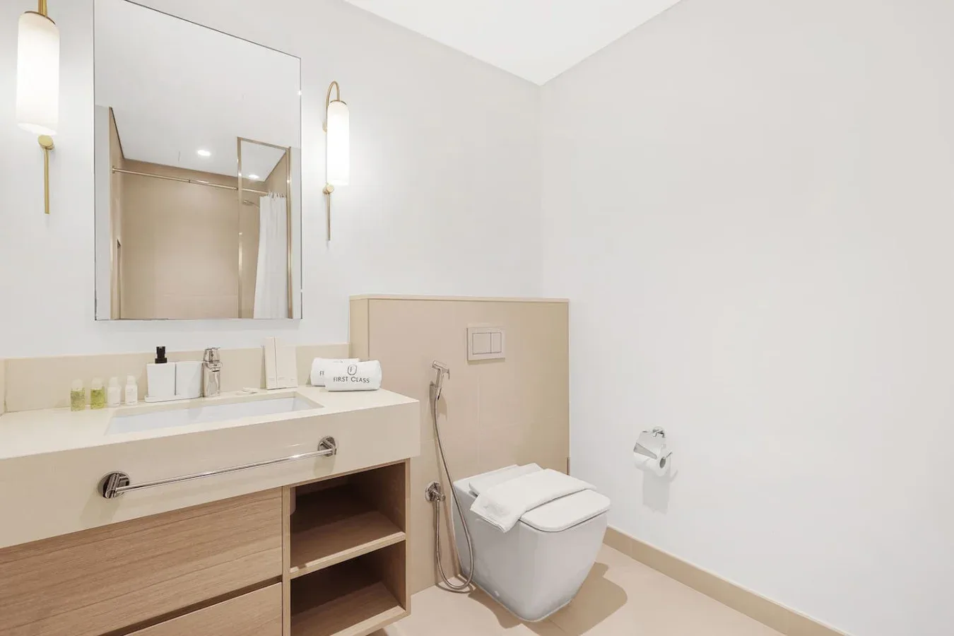 A bright bathroom with a vanity, mirror, and toilet.