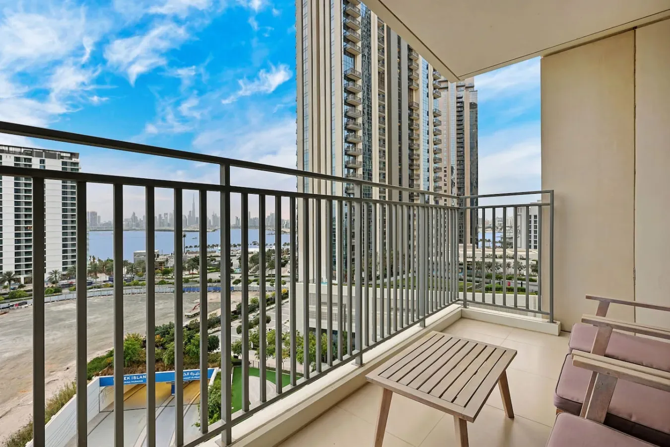A balcony with a slatted table and views of nearby high-rise buildings.