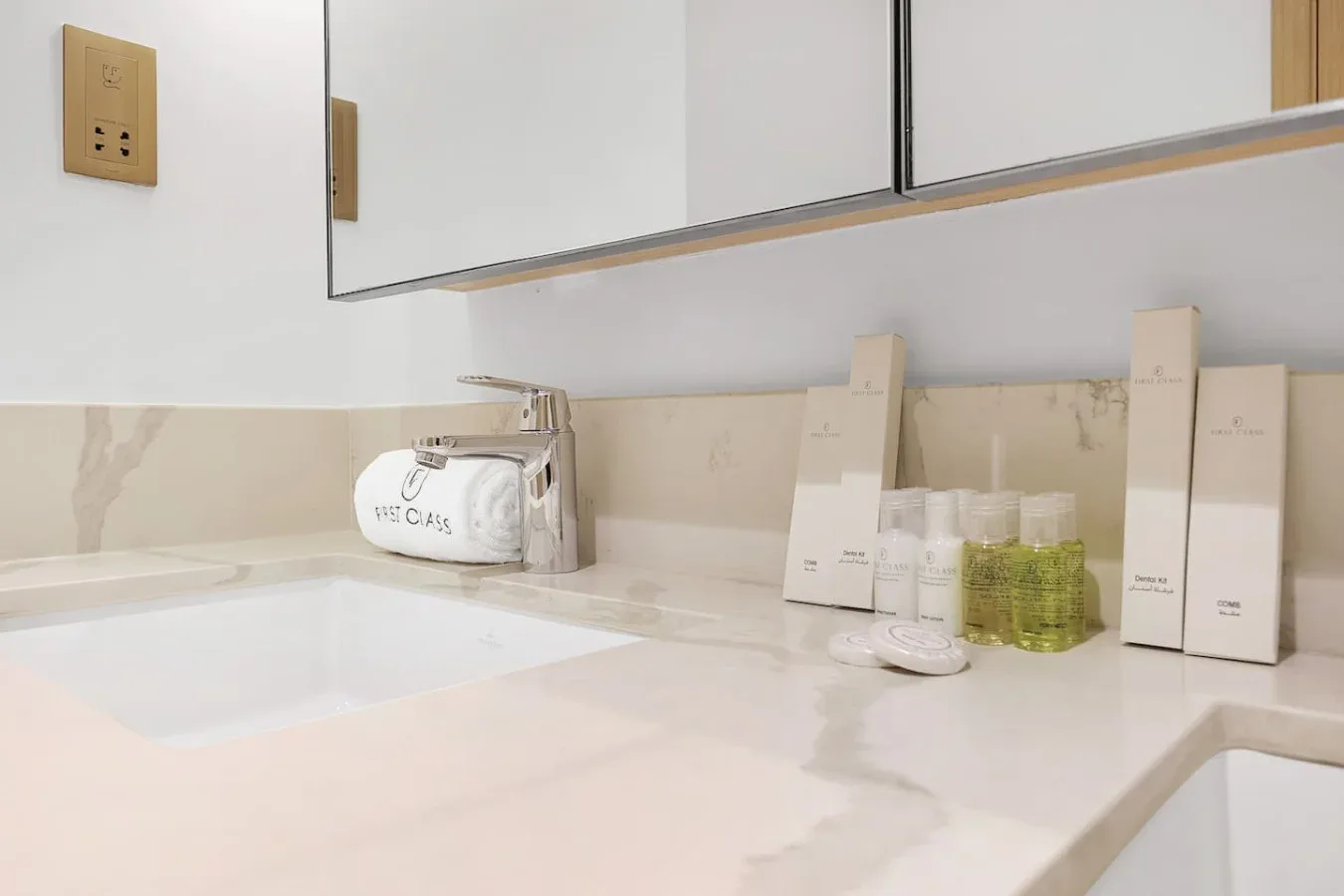 A bathroom vanity with a sink, mirror, and toiletries arranged on the counter.