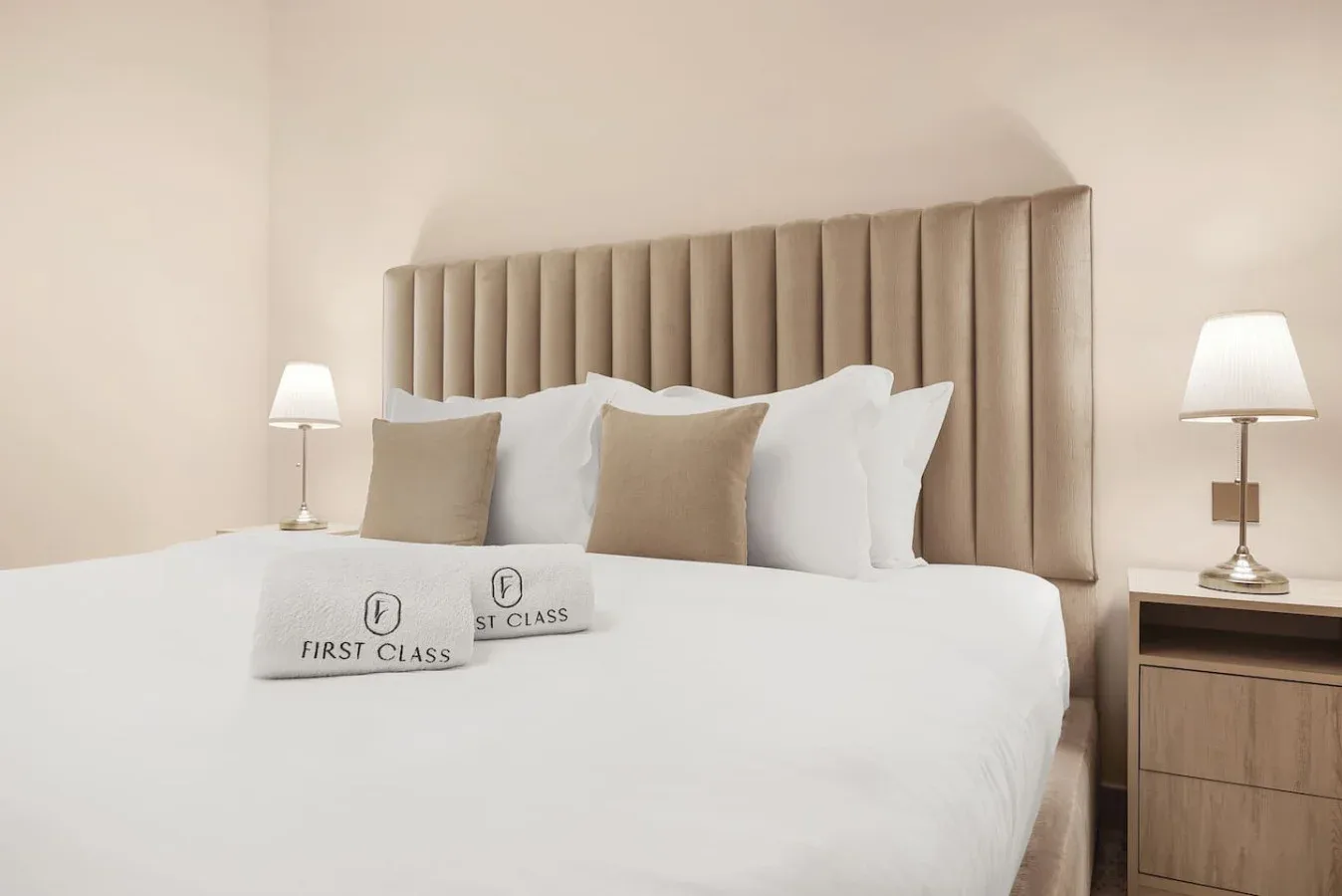 A bedroom with a neatly made bed and matching bedside lamps.