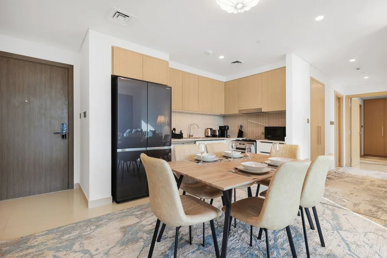 An open-plan kitchen and dining area with a wooden table and light-colored seating.