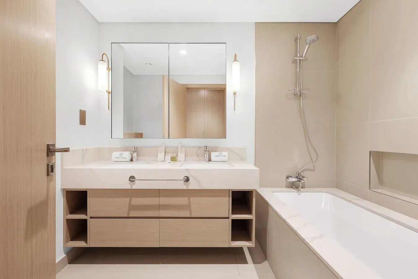 A bathroom with a wide vanity, mirror, and bathtub.