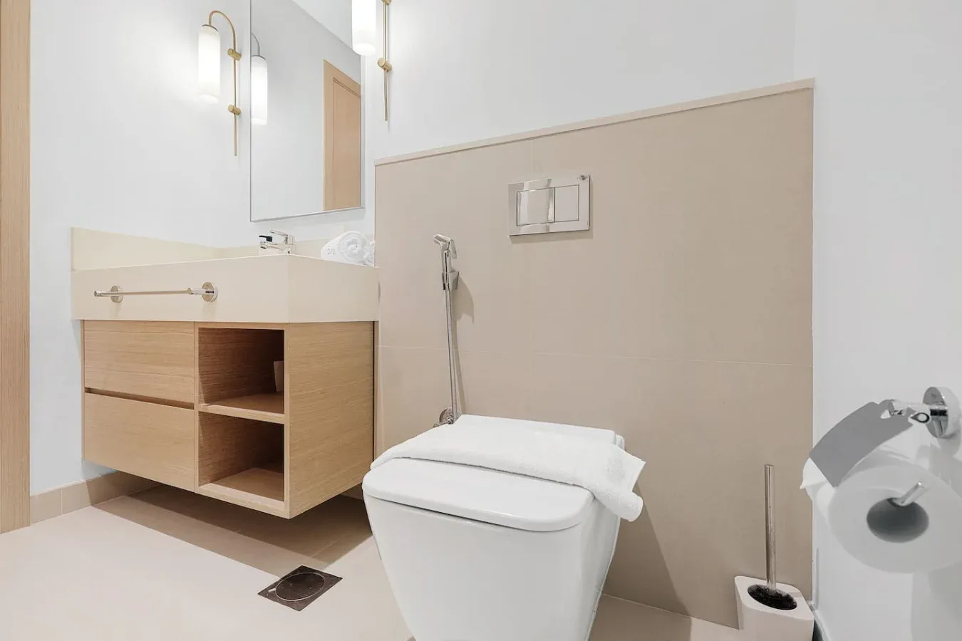 A modern bathroom with a wall-mounted sink vanity and toilet.