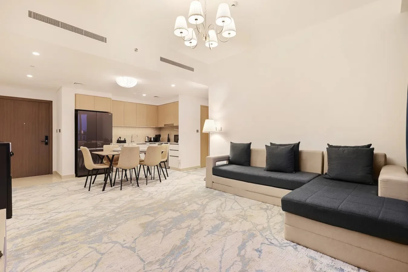 A bright living and dining area with a sectional sofa and a table.