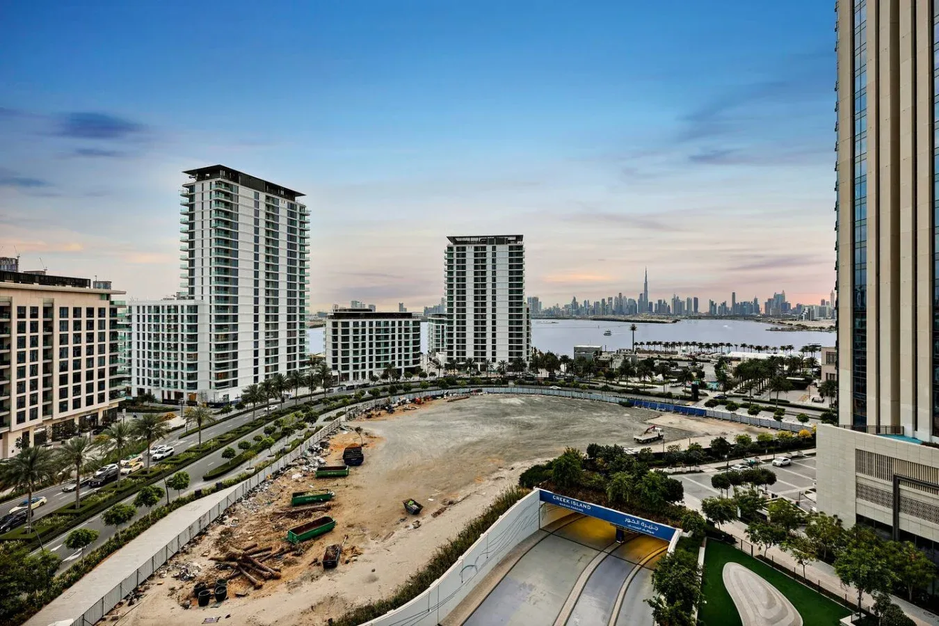 City skyline and waterfront viewed across nearby buildings and a construction site.