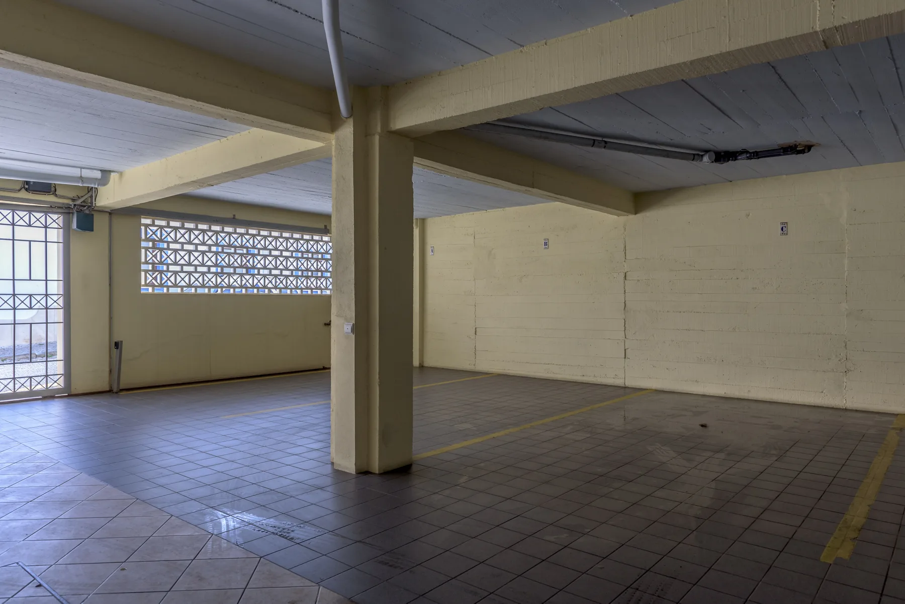 An open tiled indoor space with painted walls and a support column.
