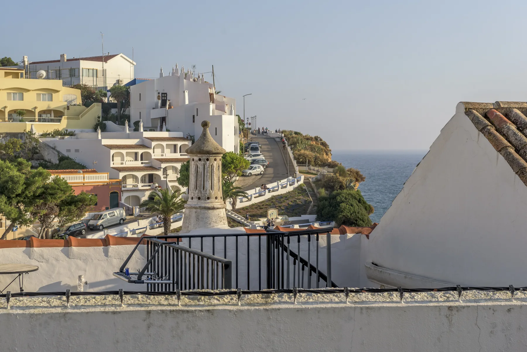 A coastal town and the sea are visible from a terrace.