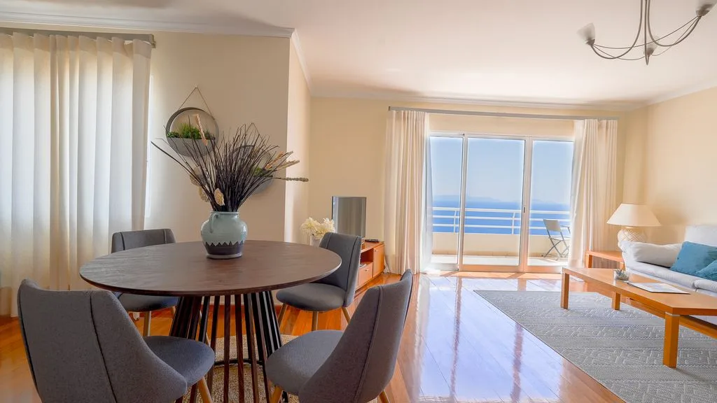Una luminosa sala de estar y comedor se abre a un balcón con vistas al mar.