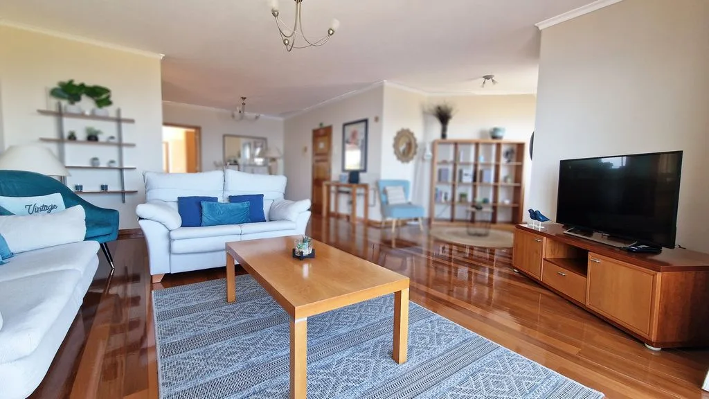 Una sala de estar con asientos, una mesa de centro y un televisor.