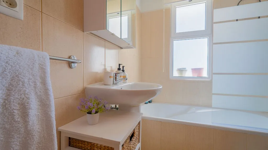 Un baño con lavabo, bañera y ventana.
