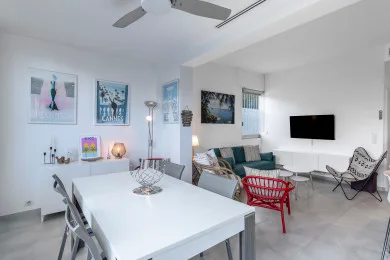 A bright open-plan living and dining area with a table and seating.