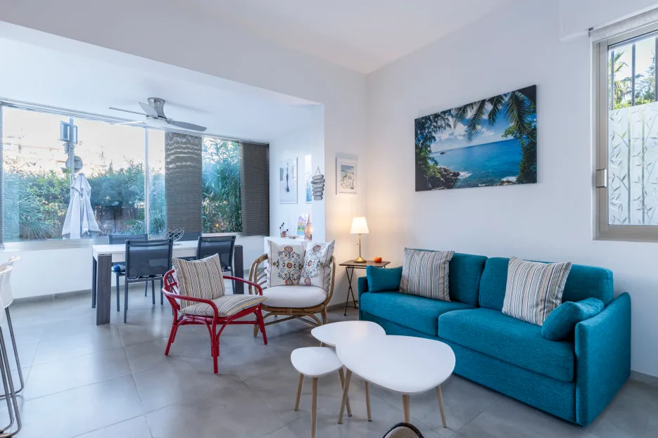 A bright living room with turquoise seating and a white coffee table.