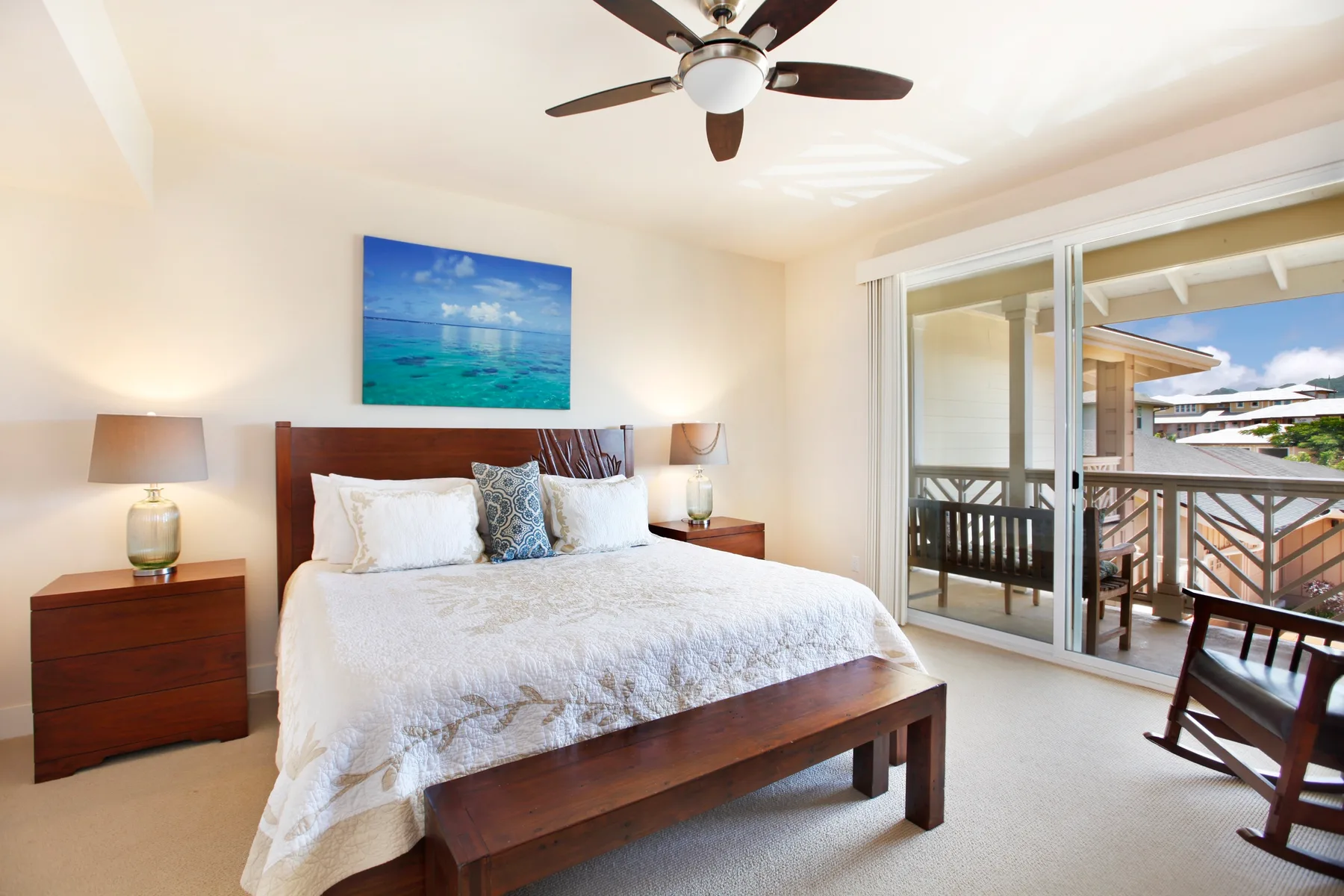 A bedroom with a bed and sliding glass doors opening onto a balcony.