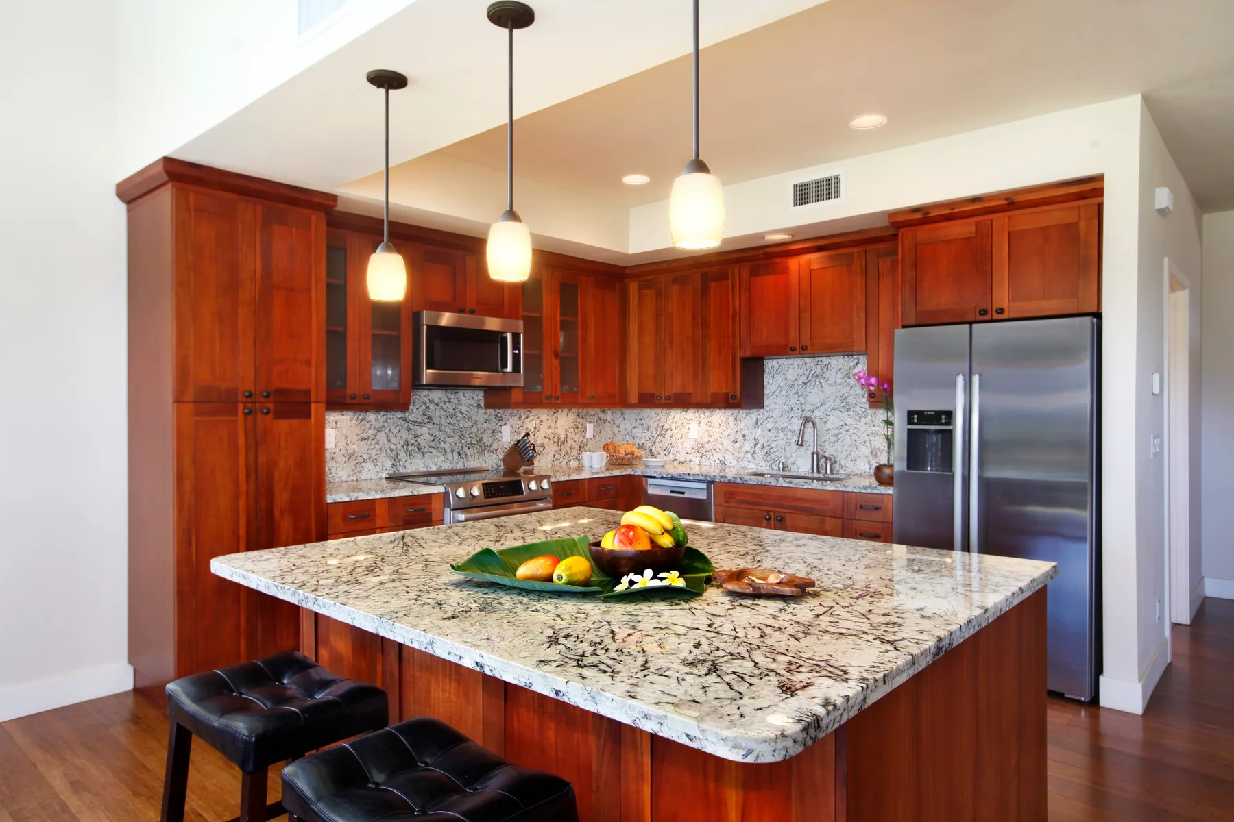 Una cocina amplia con gabinetes de madera y una gran isla de piedra.