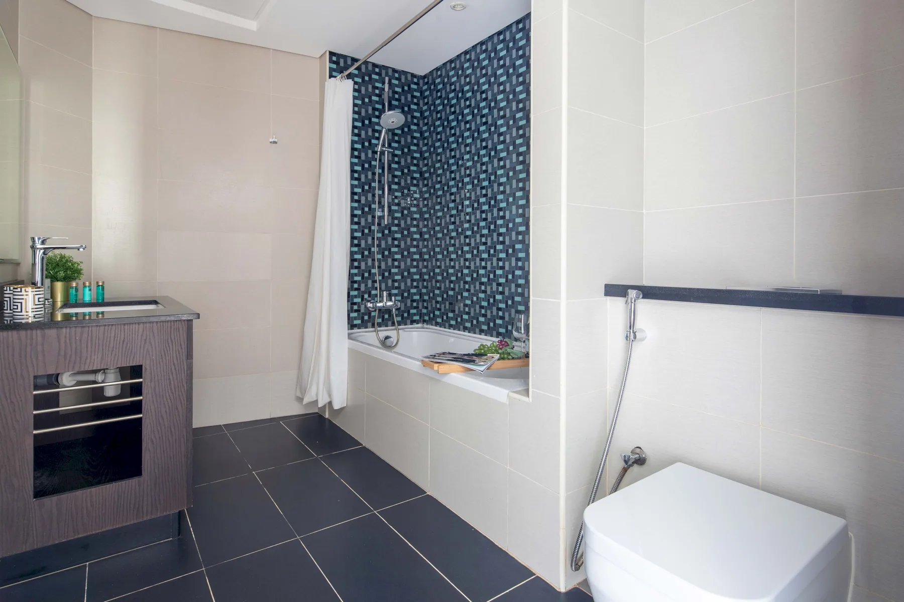 Un baño alicatado con ducha, lavabo e inodoro.