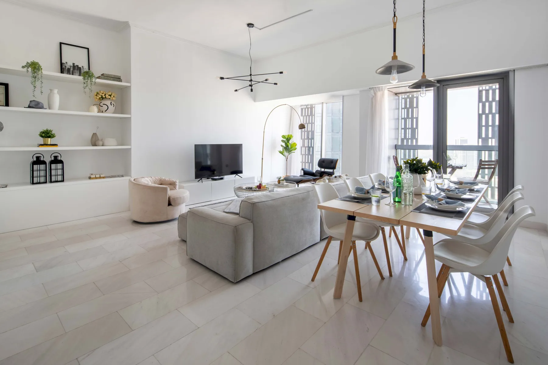 Una luminosa sala de estar y comedor de concepto abierto, con un sofá y una mesa puesta.