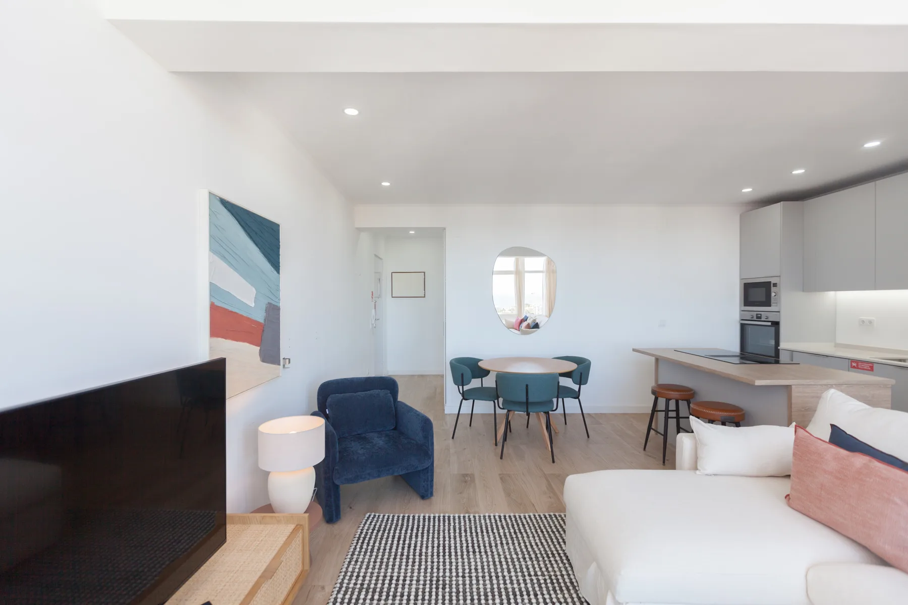 A bright open-plan living room with a dining area and compact kitchen.