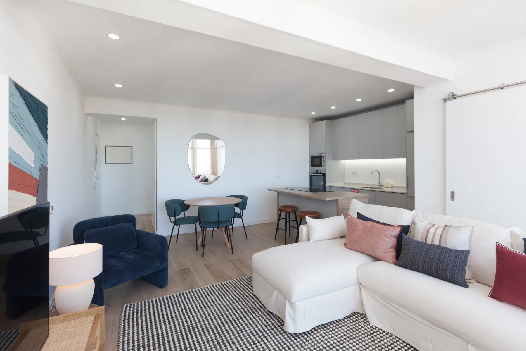 Open-plan living and dining area with a kitchen and light-colored seating.