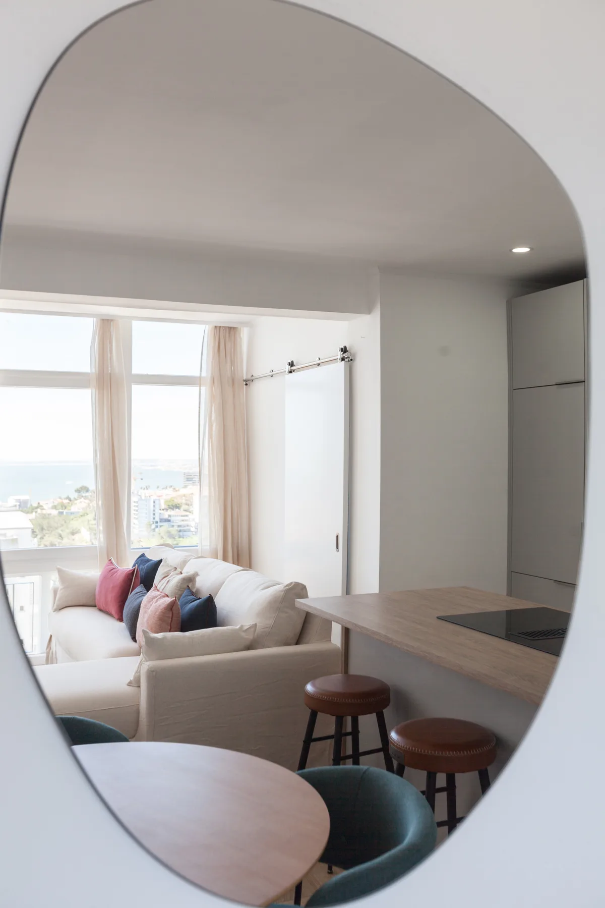 Living area with seating beside large windows overlooking the coast.
