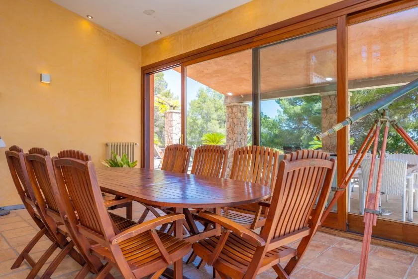 A dining area with a wooden table and seating beside large glass doors.