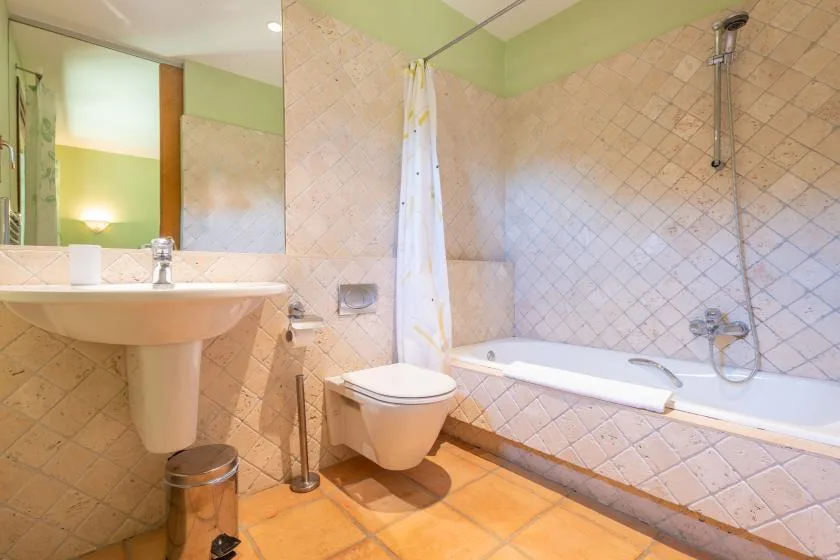 A bathroom with a sink, toilet, and bathtub with a shower.